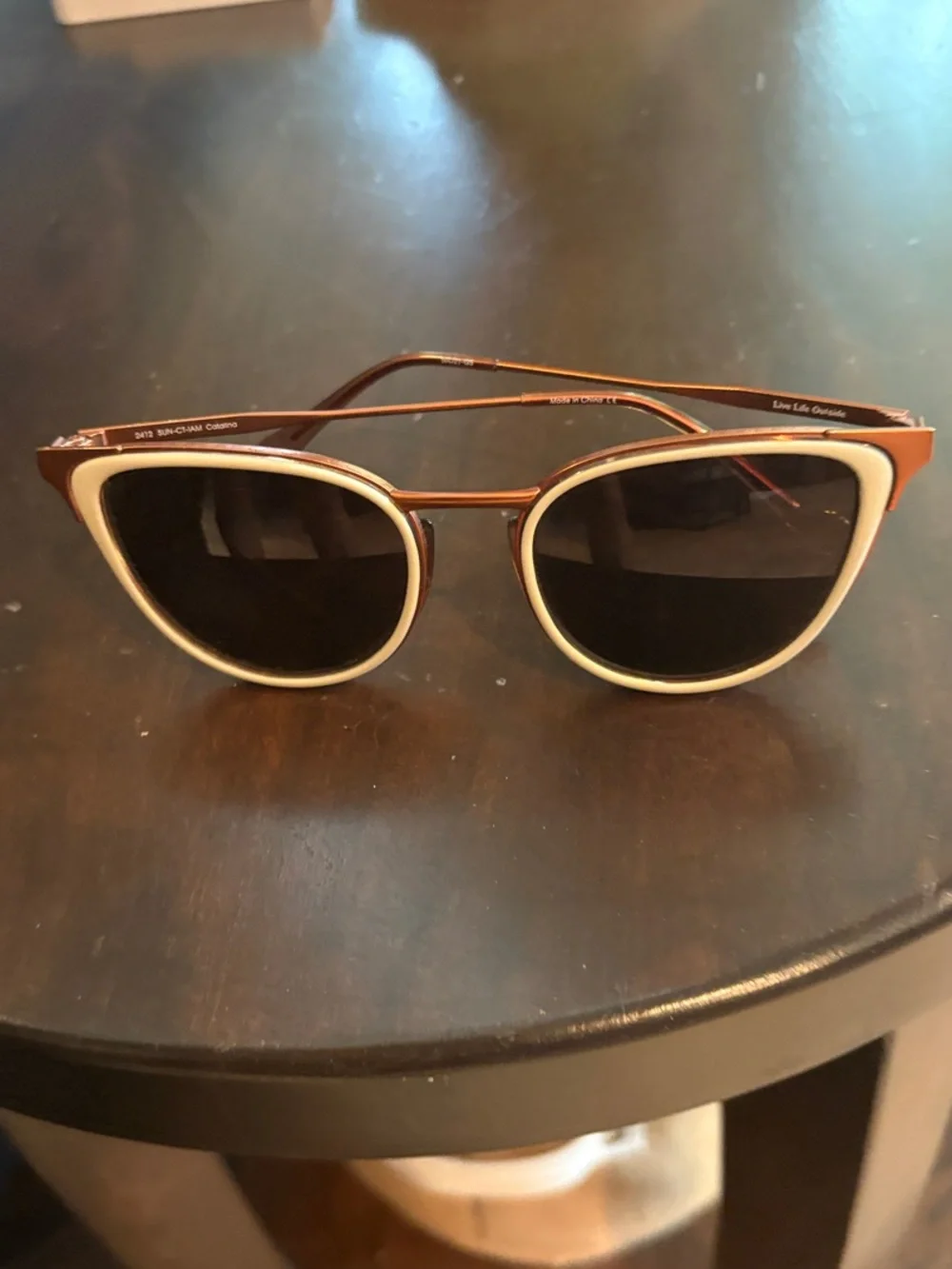 Women's sunski Sunglasses with amber frame and white trim on Black Lenses